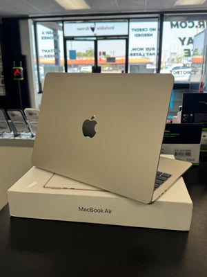 MacBook Air on display in a store with an Apple logo visible