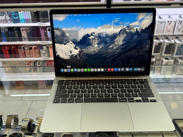 Laptop on display with a mountainous landscape on the screen, surrounded by electronic components.