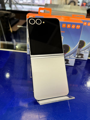 Two toned smartphone on a stand on a blue surface