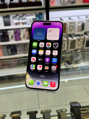 A black iPhone with a purple and blue gradient lock screen wallpaper, displayed in a retail store glass case.