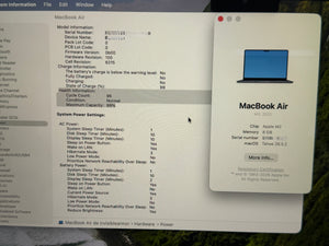 A close-up of a computer screen showing the Apple MacBook Air product information page, with text details on the left and a laptop graphic on the right. The screen is photographed at an angle with some glare and slight blur.