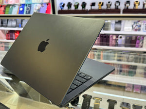 Silver laptop with Apple logo on a glass surface in a store setting