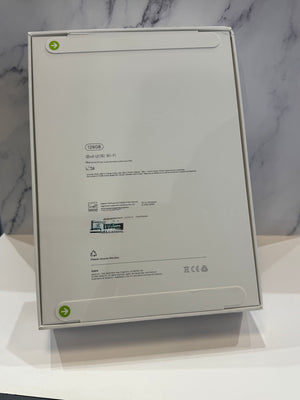The back of a white IKEA iPad 10.9-inch WiFi box, showing product specifications, barcodes, and recycling arrows, displayed on a white surface against a gray marble-patterned background.
