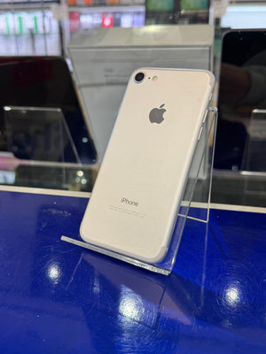 White iPhone on a clear stand with a blurred store background
