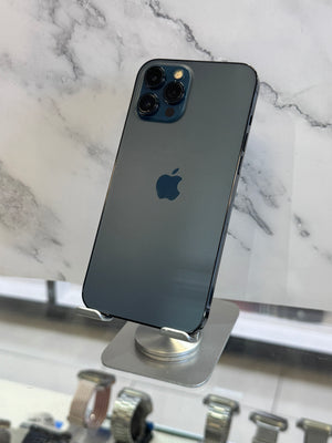 A dark gray Apple iPhone with a blue-tinted camera module, shown from the back and mounted on a display stand against a white marble-patterned background.