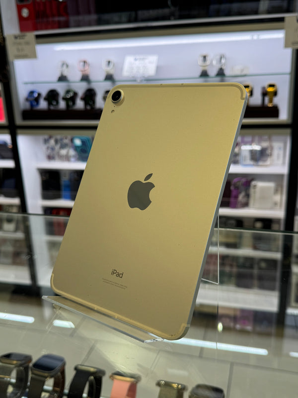 Gold iPhone with Apple logo on a reflective surface