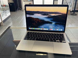 Laptop on a glass table with a scenic wallpaper