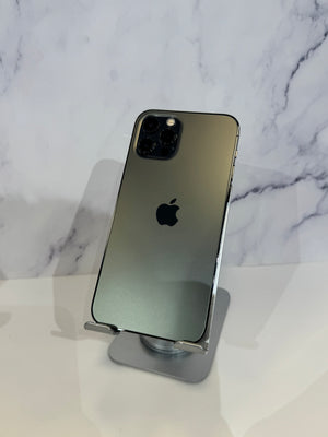 An Apple iPhone 12 Pro shown from the back, resting on a silver metal stand against a white marble-patterned background.