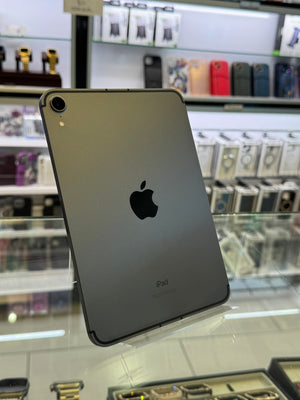 Silver iPad on display in a store with various phone cases in the background