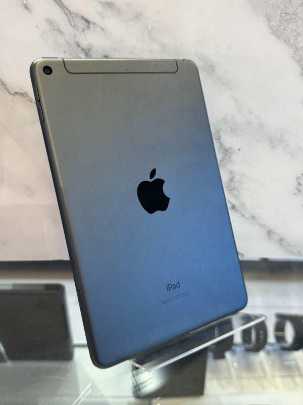 A silver Apple iPad shown from the back, standing upright on a clear display stand against a white marble-patterned background.