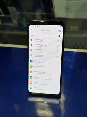 Smartphone displaying a settings menu on a reflective surface