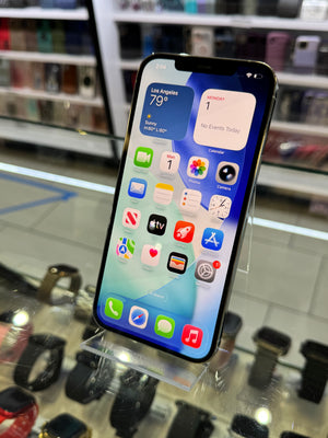 Smartphone with app icons displayed on a screen, held in front of a store display.