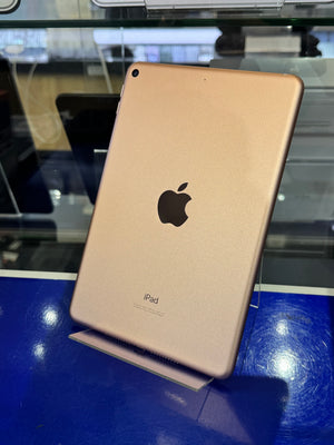Gold Apple iPad case on a blue surface with reflections.