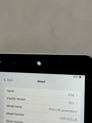A close-up of an iPad screen showing the 'About' screen with iPadOS Version 18.5 and model name 'iPad (7th generation)'.