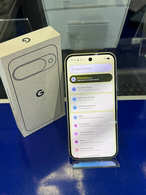 Smartphone with setup screen next to its packaging on a reflective surface