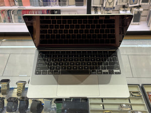 Open laptop on a glass table with a store shelf in the background