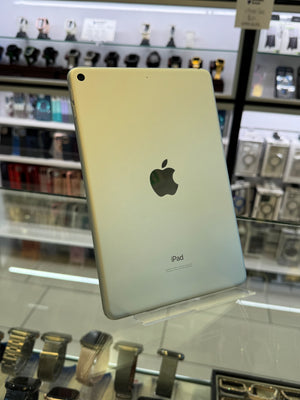 Back view of a gold iPad with Apple logo on a blurred store background