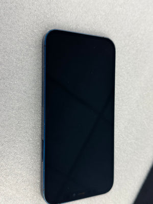A blue smartphone with a black screen, photographed from an angled side view on a textured light gray surface.