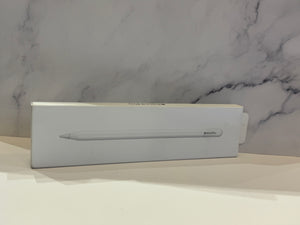 A white Apple Pencil box with the Apple logo and product name printed on the front, resting on a white surface against a gray and white marble-patterned background.