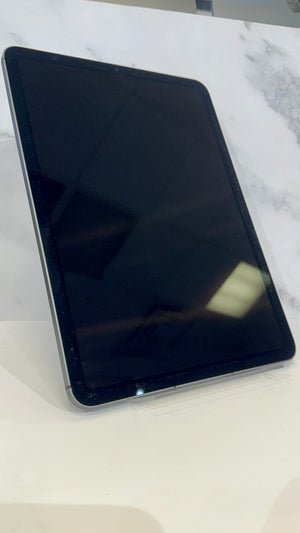 A black tablet with a glossy screen, shown standing at an angle on a white marble-patterned surface.