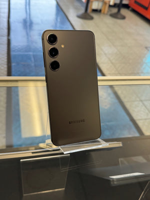 Samsung smartphone on a stand with a blurred indoor background