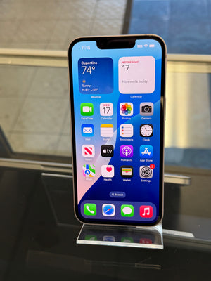 Smartphone with app icons displayed on a stand against a glass door background
