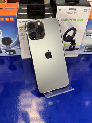 Silver smartphone with Apple logo on a blue surface with car mount packaging.