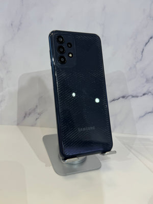 Samsung Galaxy S20 Ultra smartphone in dark navy blue, standing upright on a clear acrylic display stand against a white marble-patterned background.