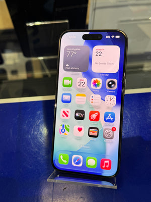 Smartphone displaying app icons on a reflective surface with a blue background