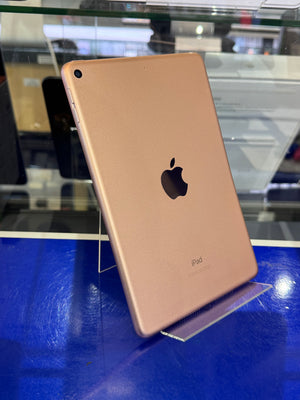 Gold Apple iPad on a blue surface with reflections