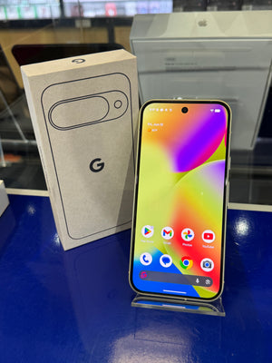 Smartphone with colorful display next to its packaging on a reflective surface
