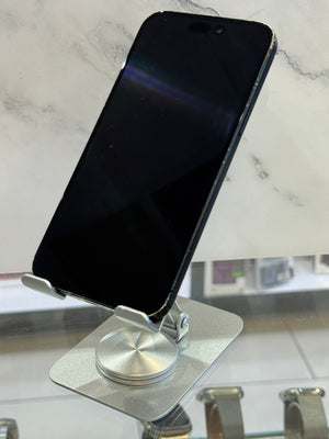 A black smartphone resting on a silver metal magnetic stand attached to a glass surface, with a white marble-patterned background.