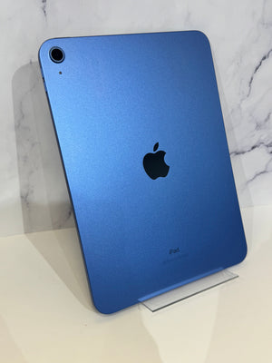 A blue Apple iPad shown from the back, leaning on a clear acrylic stand against a white marble-patterned background.