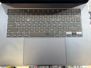 Close-up of a laptop keyboard with a focus on the keys and trackpad.