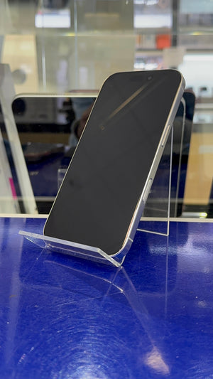A black smartphone with a silver edge, displayed on a clear acrylic stand on a reflective blue surface.