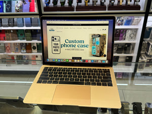 Laptop displaying a customizable phone case design tool in a store setting.