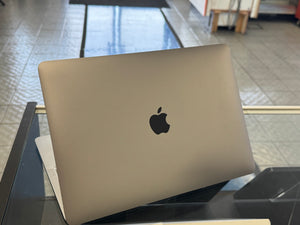 Laptop with Apple logo on a reflective surface