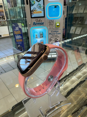 Smartwatch with pink band on a stand in a store setting