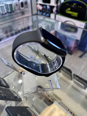 Black Apple watch on a glass surface with a blurred store background