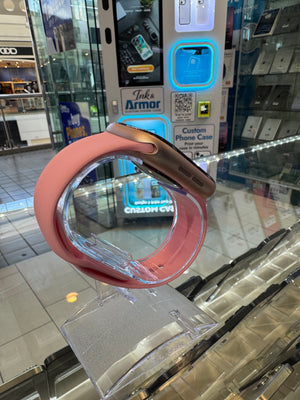 Pink smart watch with a pink band and Ink & Armor machine in the background