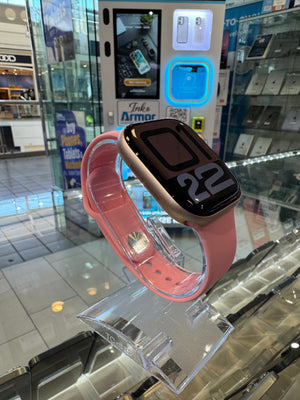 Smartwatch with pink band on a clear stand in a store setting