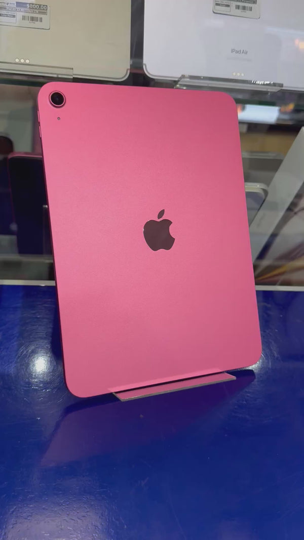 Pink Apple iPad back resting upright on an acrylic stand againt a store background